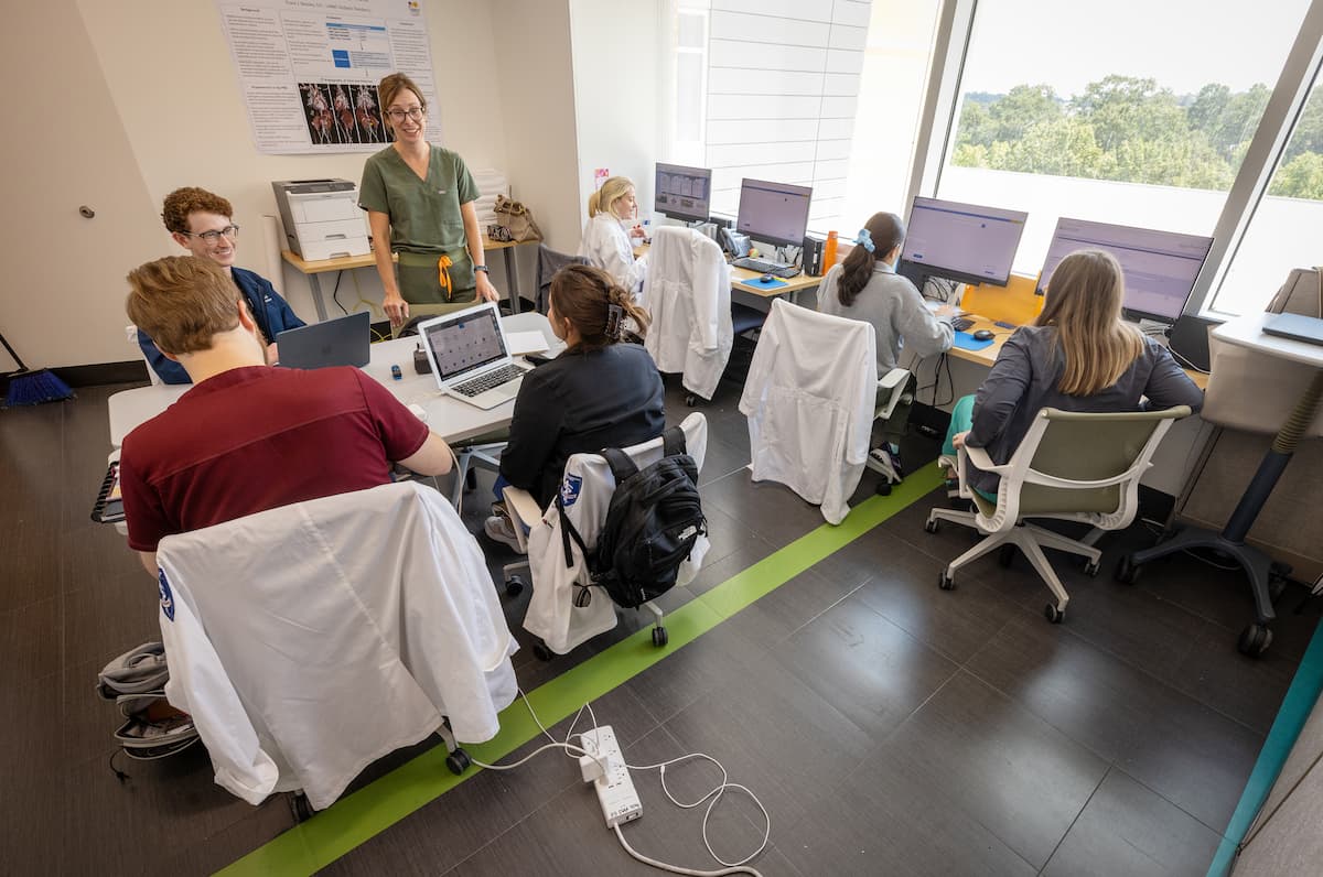 Pediatrics professor Dr. Kimberly Paduda, center, talks with medical students inside the new meeting space opened for medical students and pediatric residents.